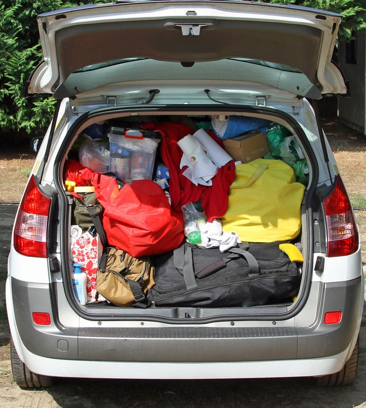 A car trunk filled with a significant amount of luggage, utilizing the storage space behind it.